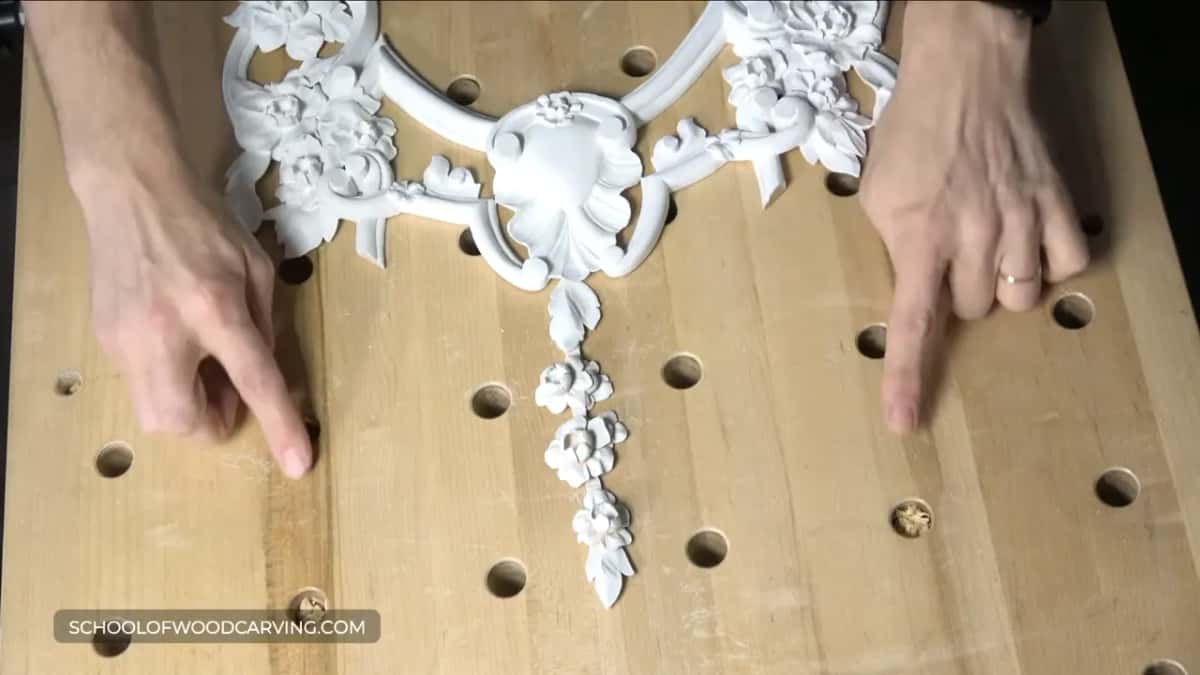 Two pieces fitted together on the bench, fingers marking where the molding will run