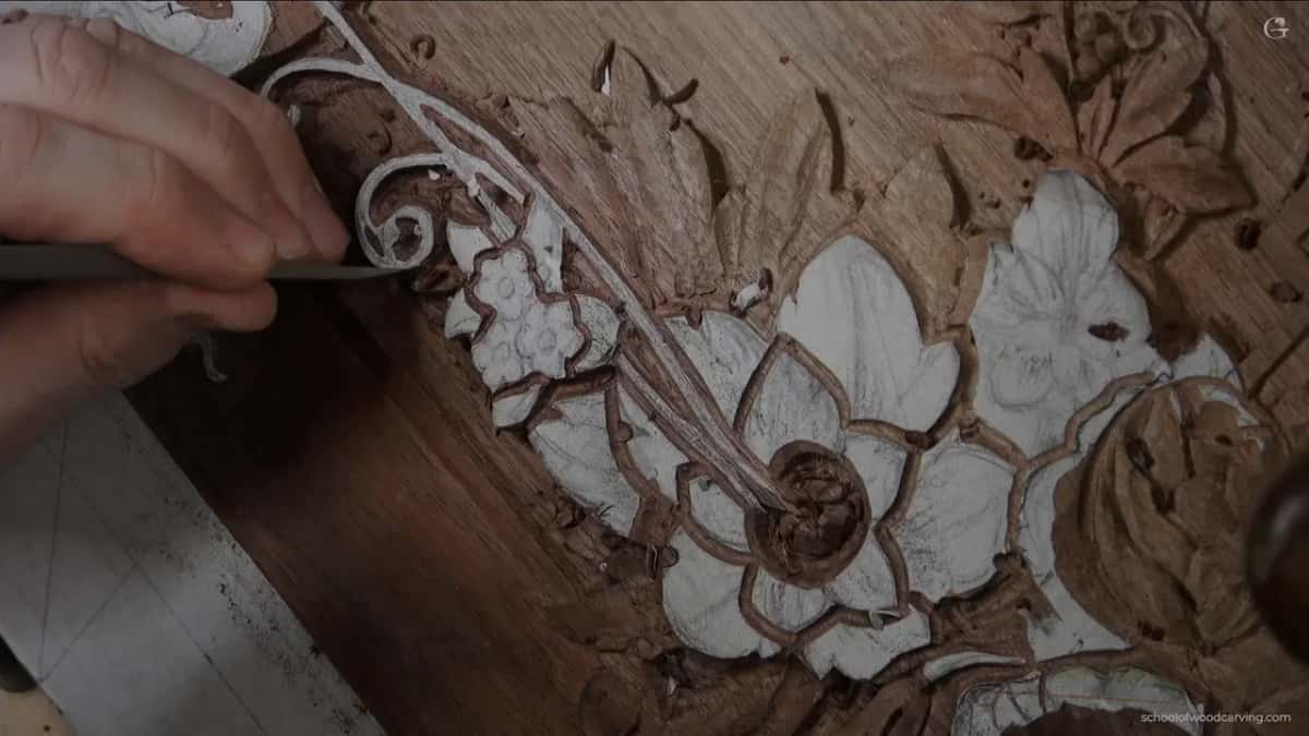 Hand and gouge above the carved scroll.