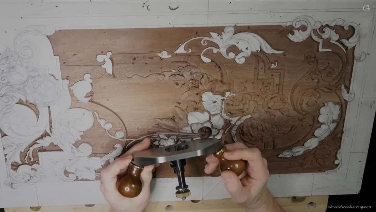 Both hands on a router plane, laid over the panel.