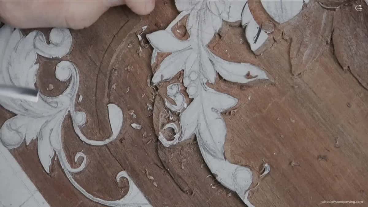 Scrolling foliage carved barely proud of its ground.