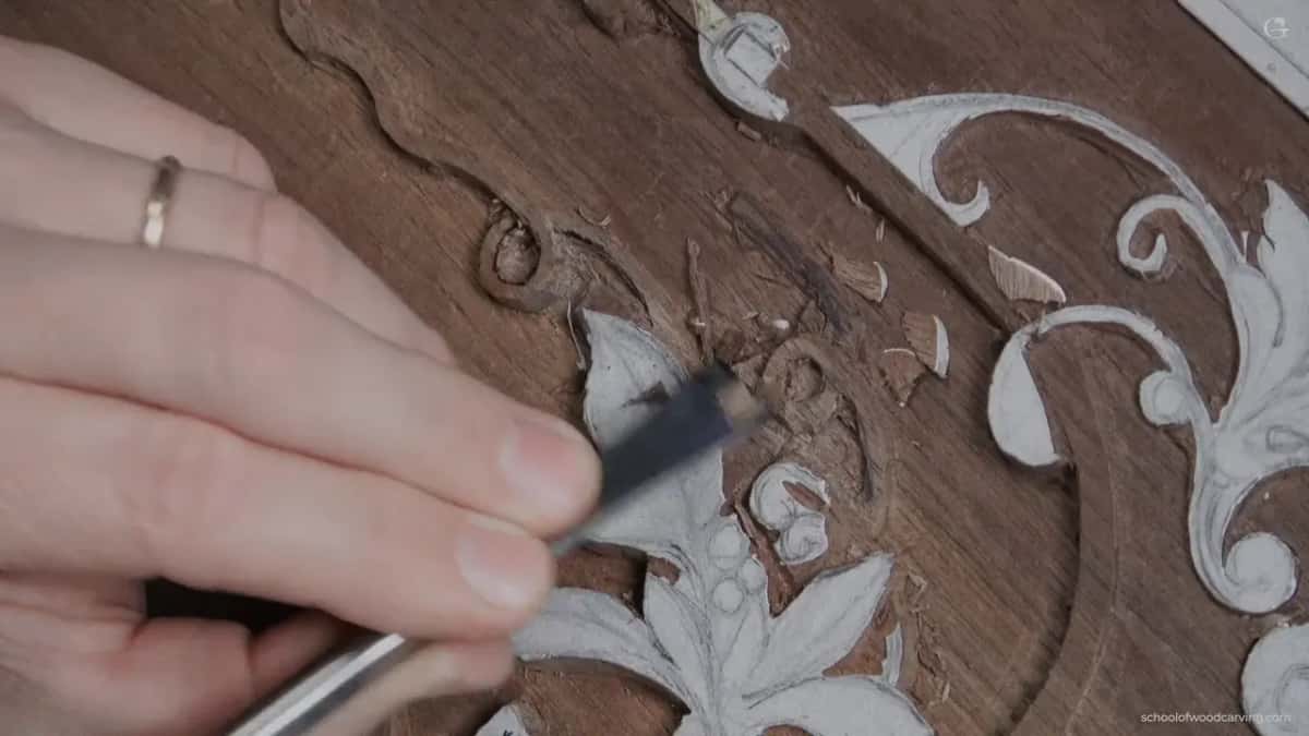 Flat blade laid almost level against a leaf, the hand barely gripping it.