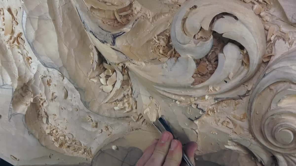 Seen from lower down, a gouge sits in a hollow on the lower lobe while the fingers steer the blade.
