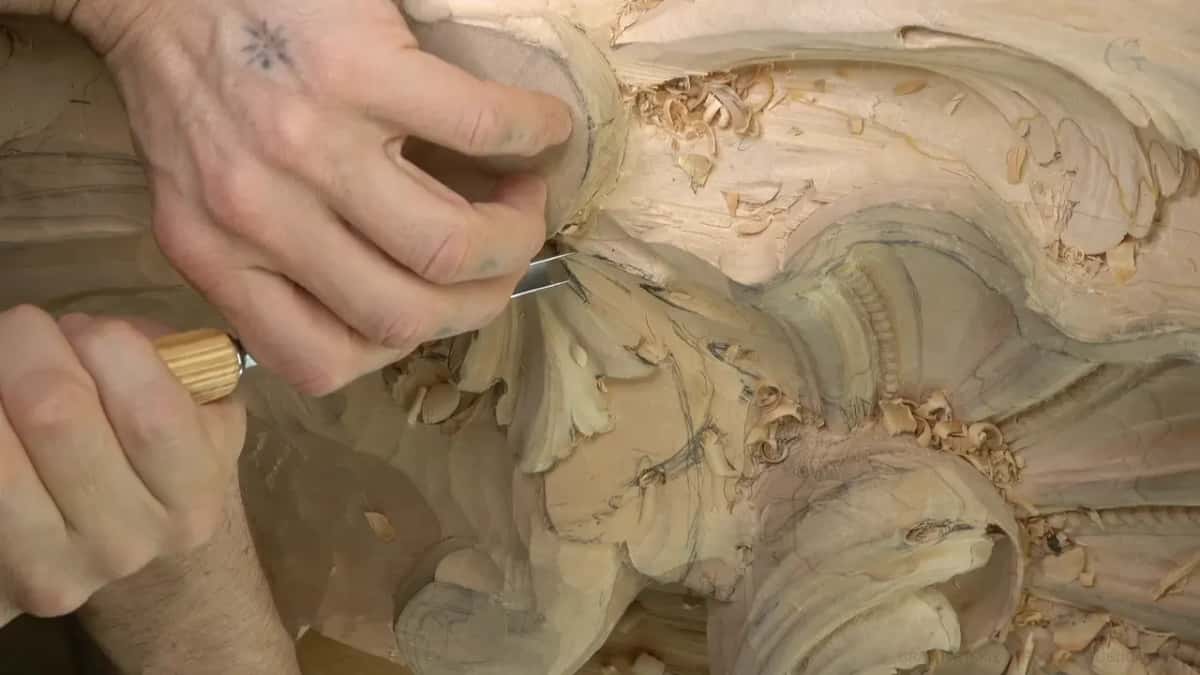 Fingers guide a gouge through a separating cut.