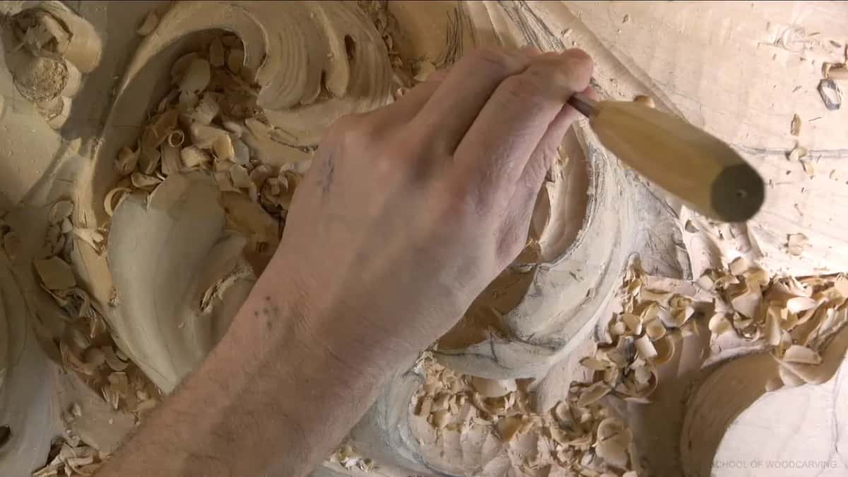 Fist around a pale handle, pressing straight down.