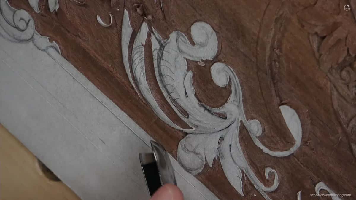 Carved scrolls with a tool at the lower edge of the frame.