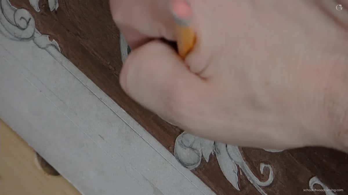 A yellow handled tool in his fist, working over the spot where the eye now sits after being moved from where it was drawn.