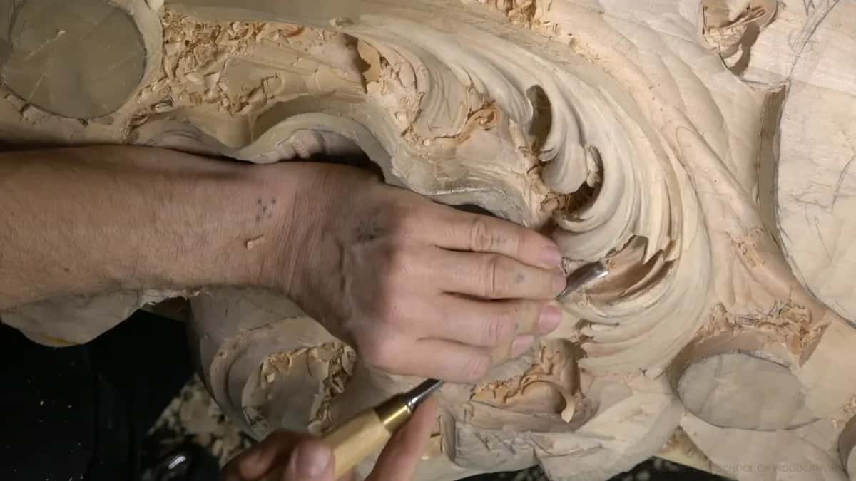 Gouge held two-handed inside a lobe's hollow.