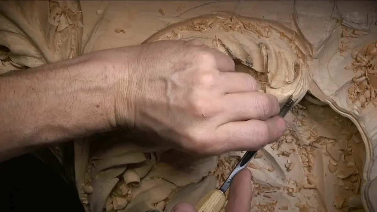 Pushing a pale handled gouge into the hollow under an acanthus curl