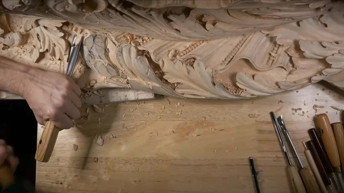 Upright in one fist, a gouge waits at the end of the carved band