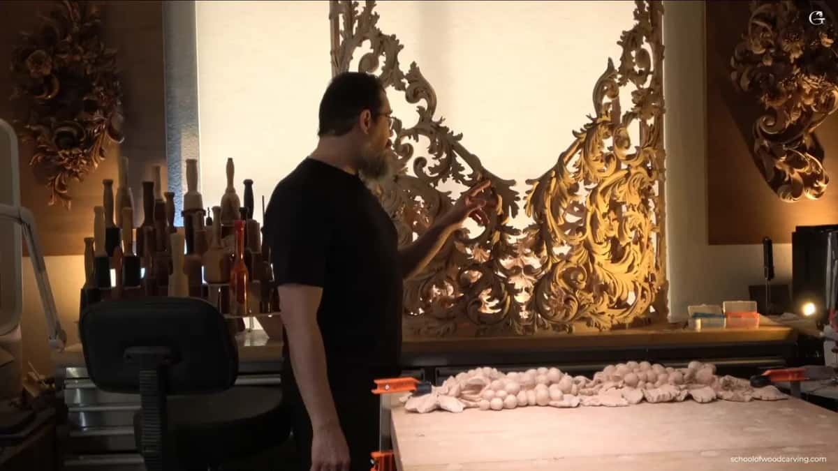 Pointing at pierced acanthus panels for a pipe organ behind the bench