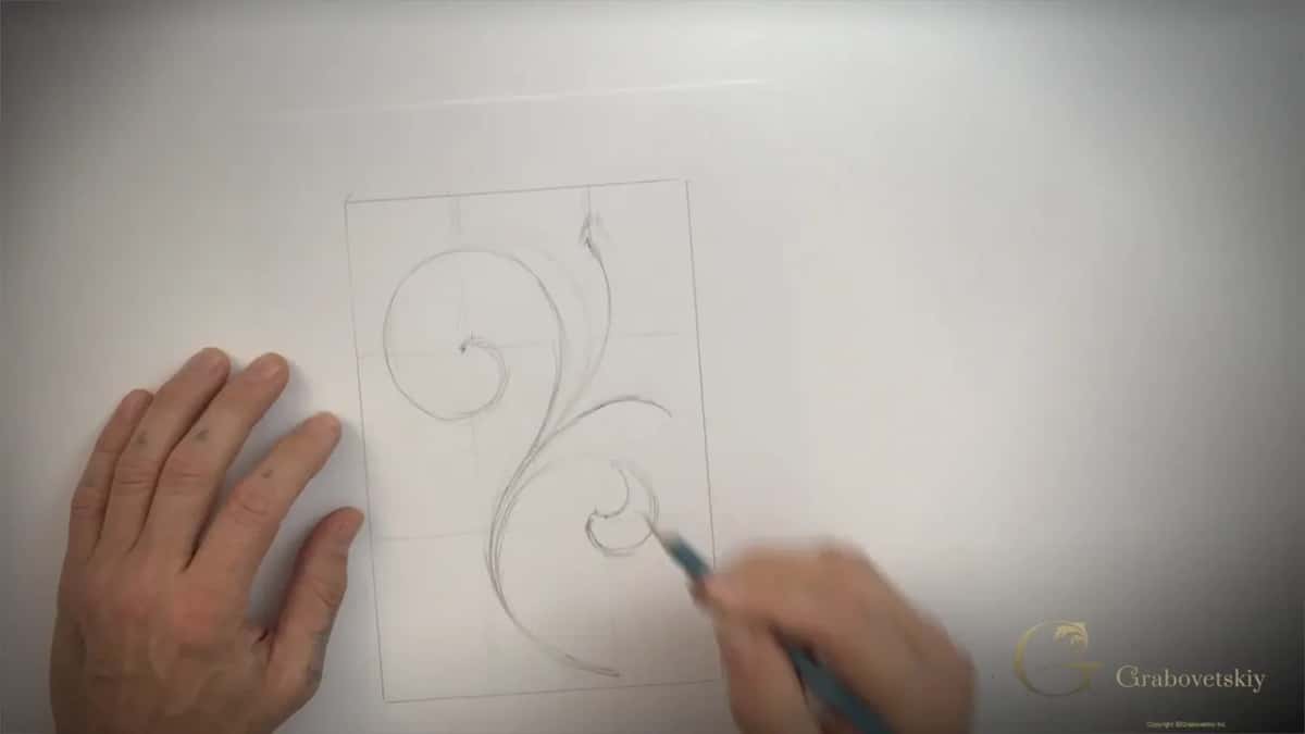 Pencil adding a second small curl inside the ruled box, the big spiral already drawn above it