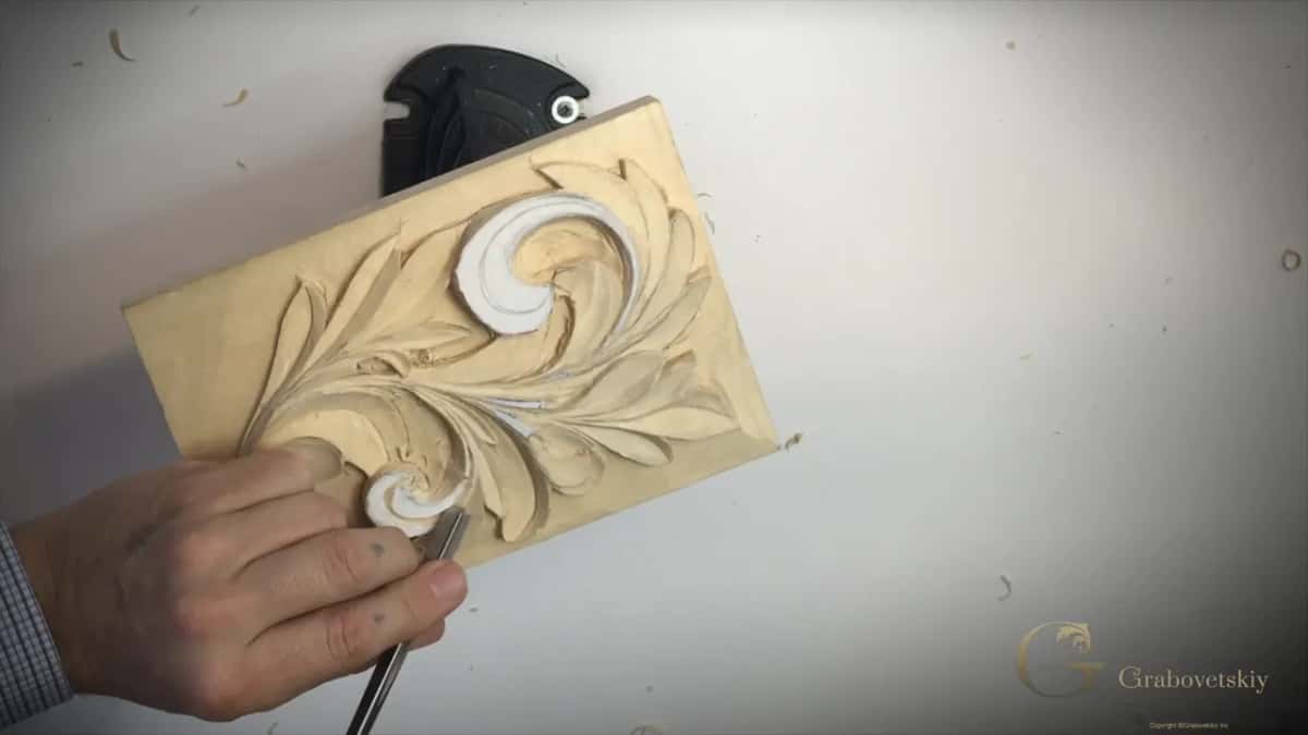Right hand on a V tool at the small curl, the panel tipped on its holder