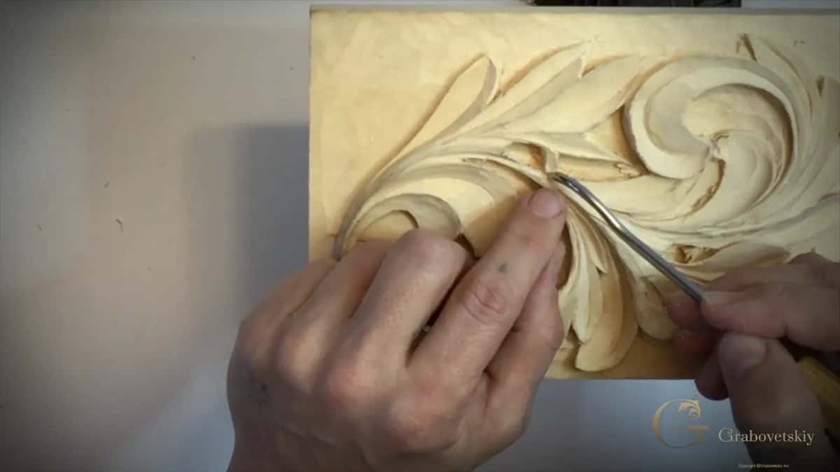 Both hands steady a bent tool against the curl