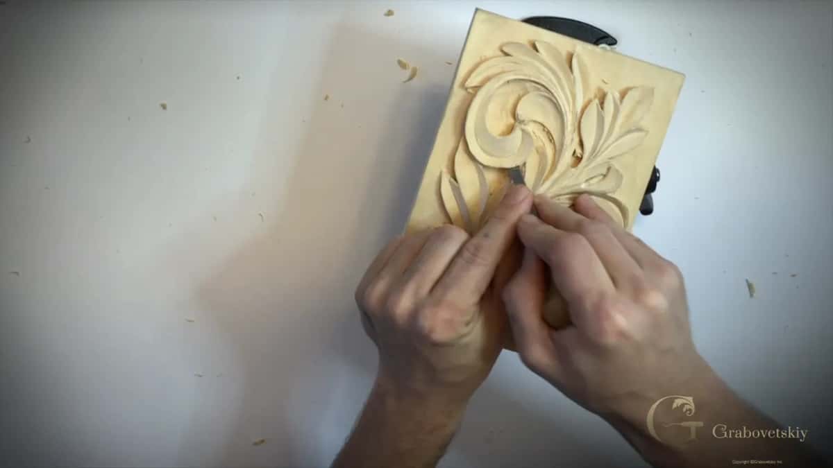 The short chisel held in both hands at the lower leaves