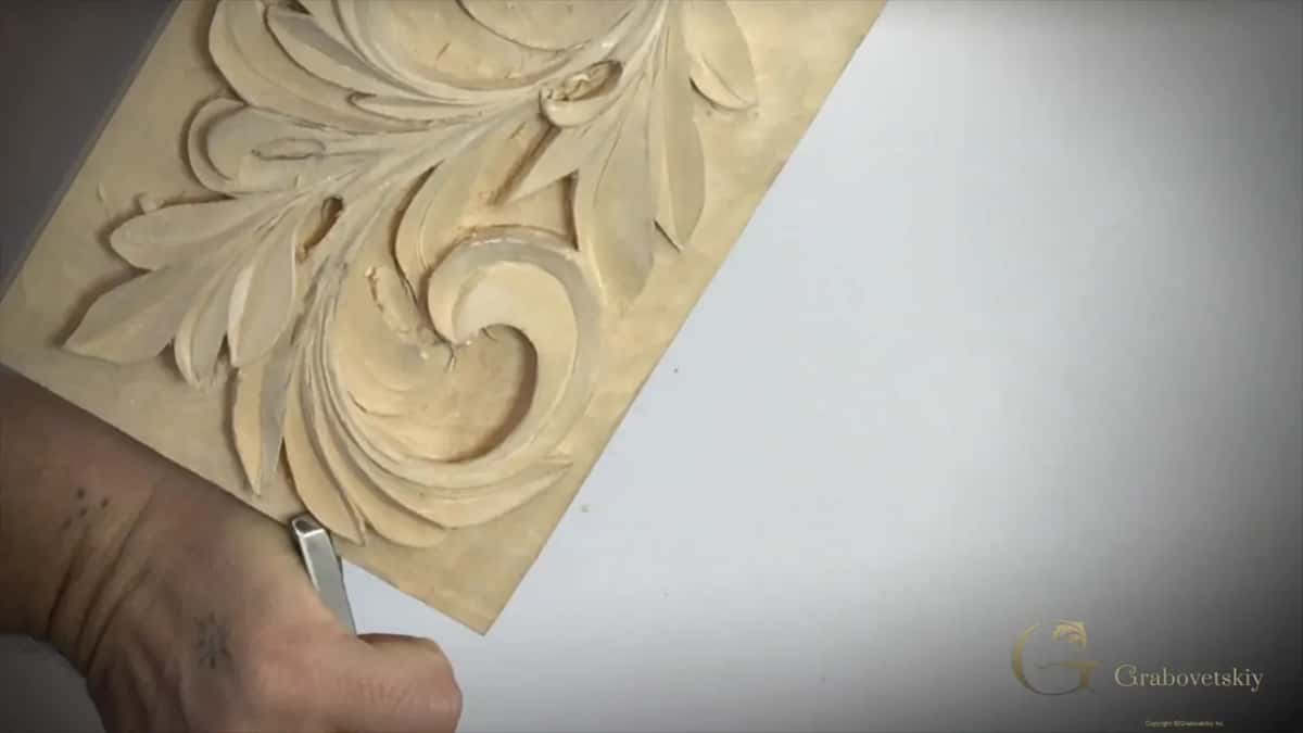 A hand at the lower corner gripping a flat tool