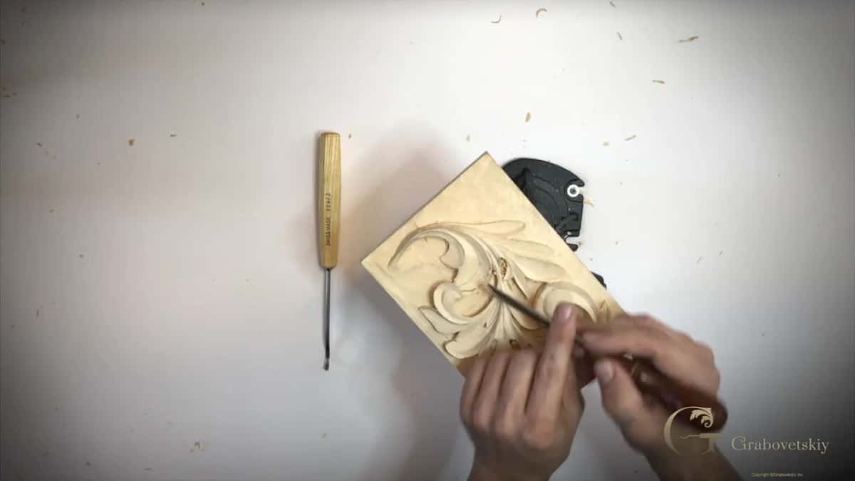 Pale handled tool on the table, hands busy on the small panel beside it