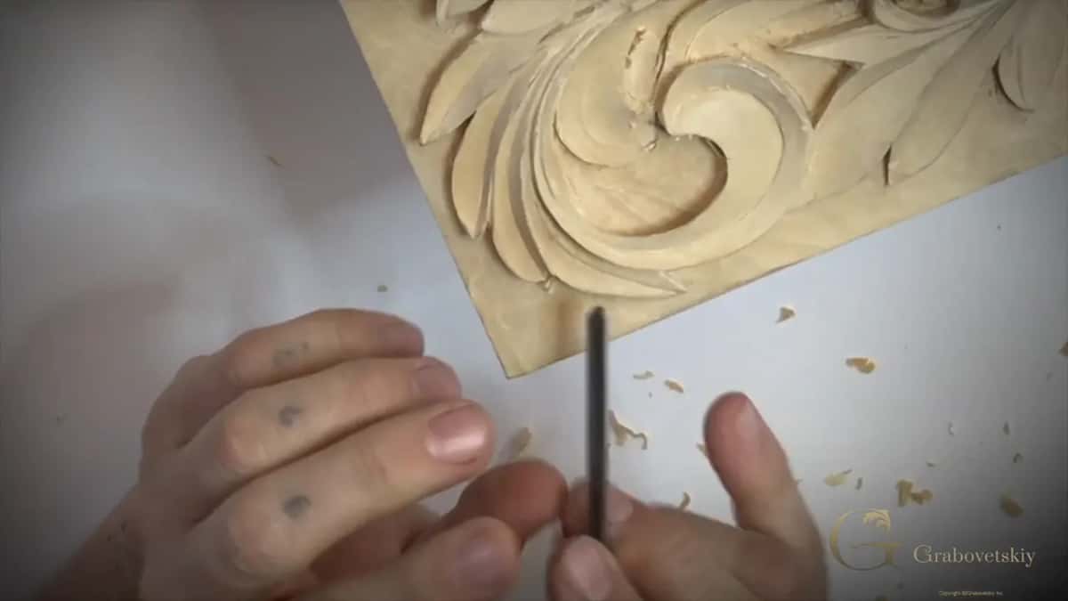 Dark slim tool upright in the fingers