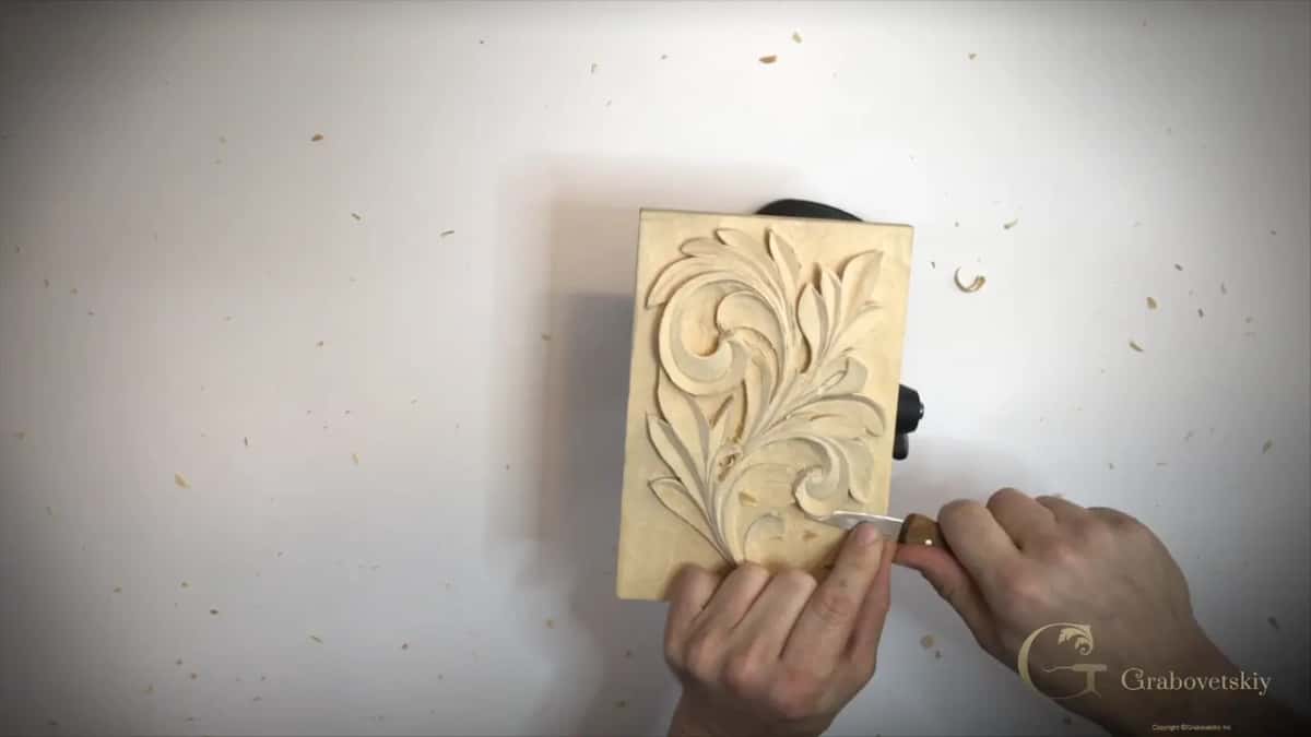 Small panel in the middle of the frame, both hands at its lower curl and chips all around