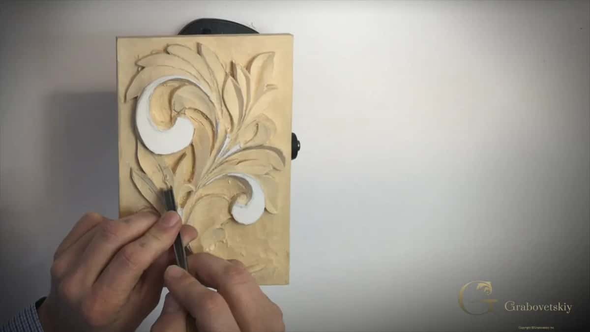 Both hands on a V tool by the base of the leaf