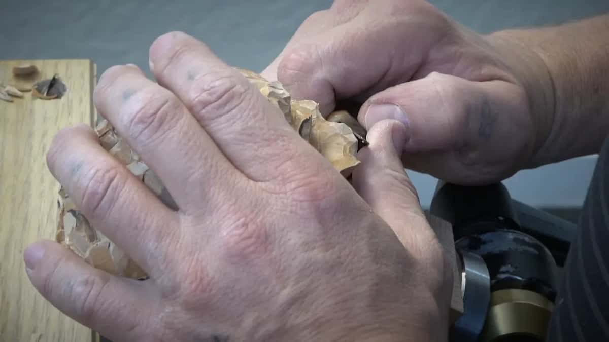 Both hands on the flower in the vise, working waviness into the edge of one petal.