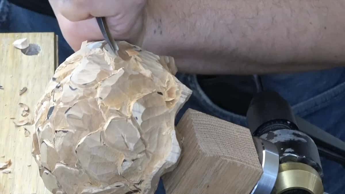 Ball on its oak block with the vise handle behind, a gouge coming in at the top left.