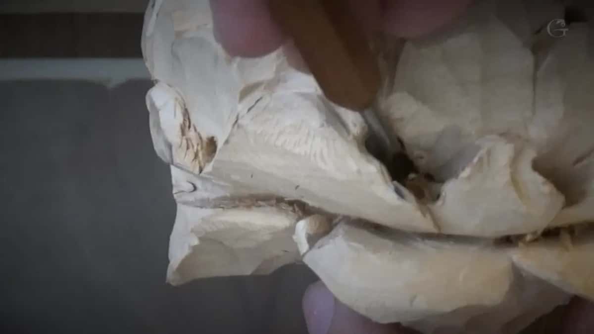 Petals carved deep with a dark opening between them, and the tool taken as far in as its own shape allows.