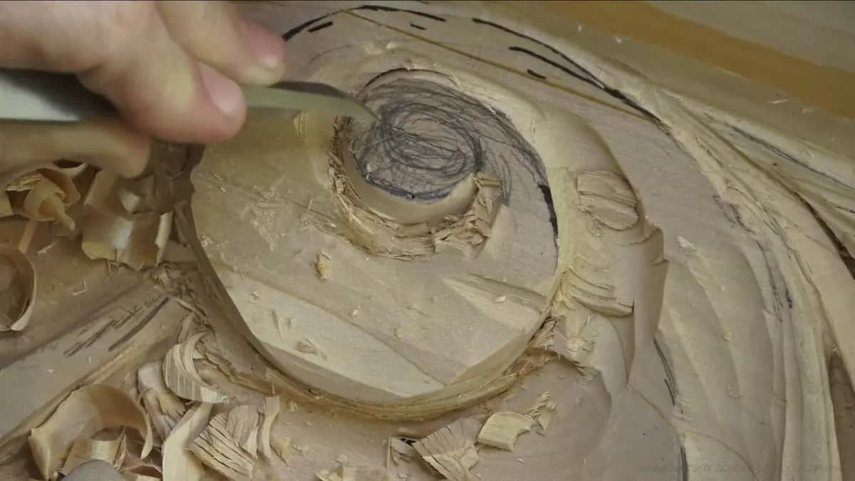 A flat tool pushed into the inner ring, curls of wood scattered around it.