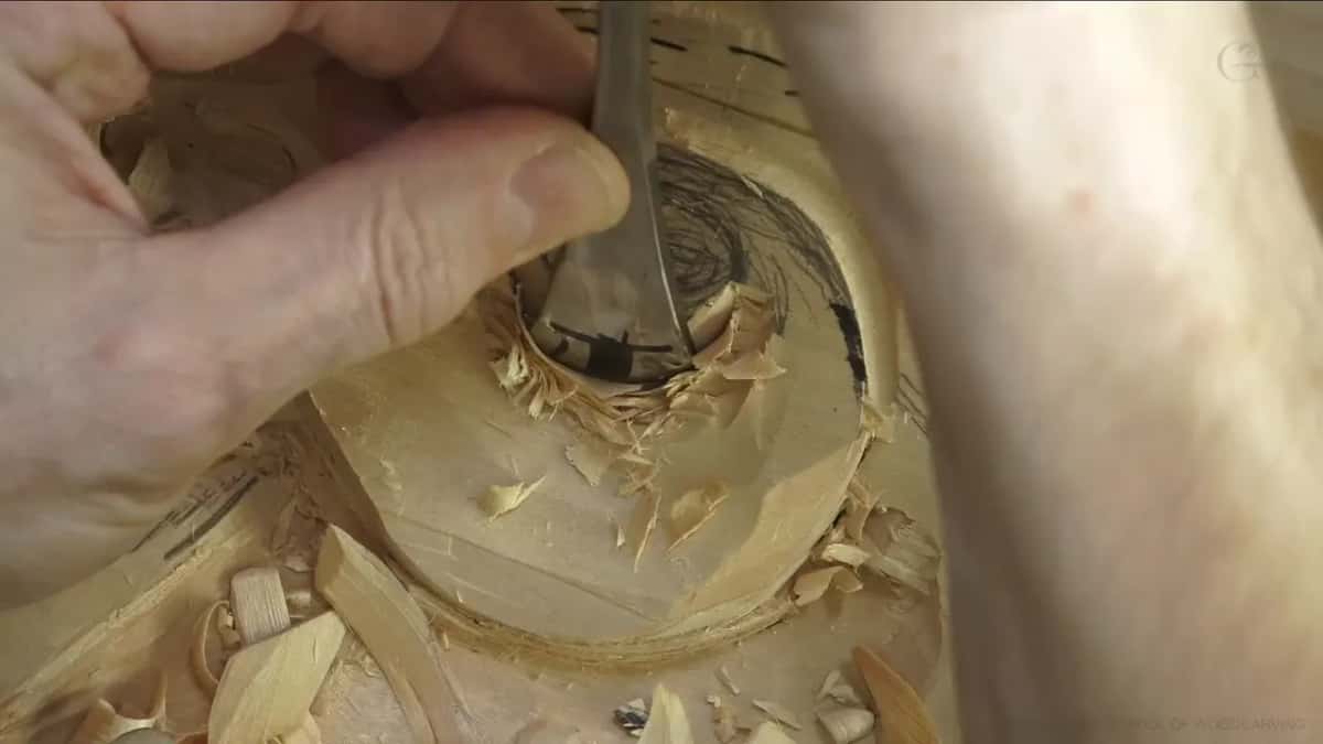 Narrow tool held upright against the ring.