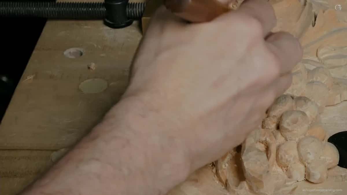 Fingers flat on the carving