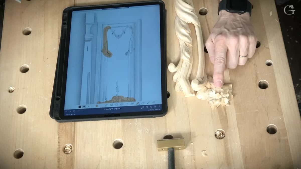 An iPad on the bench beside the carving, my finger on the spot where this piece belongs.