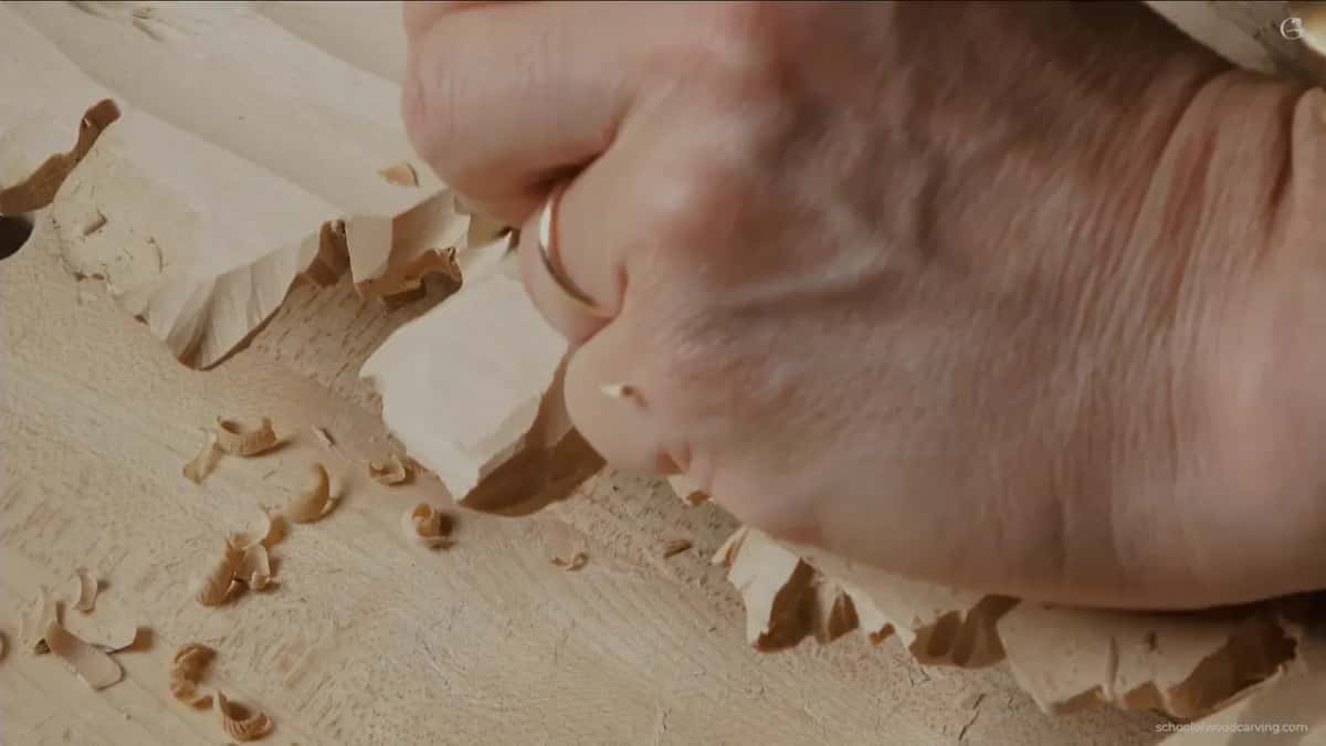 Hand flat on the hollowed reverse, feeling for thickness while the chips build up