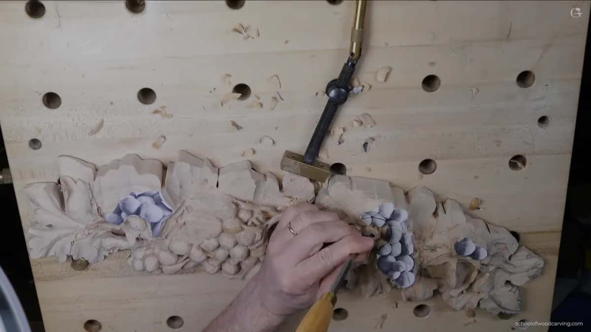 Gouge held flat to the panel while the first berries are blocked in