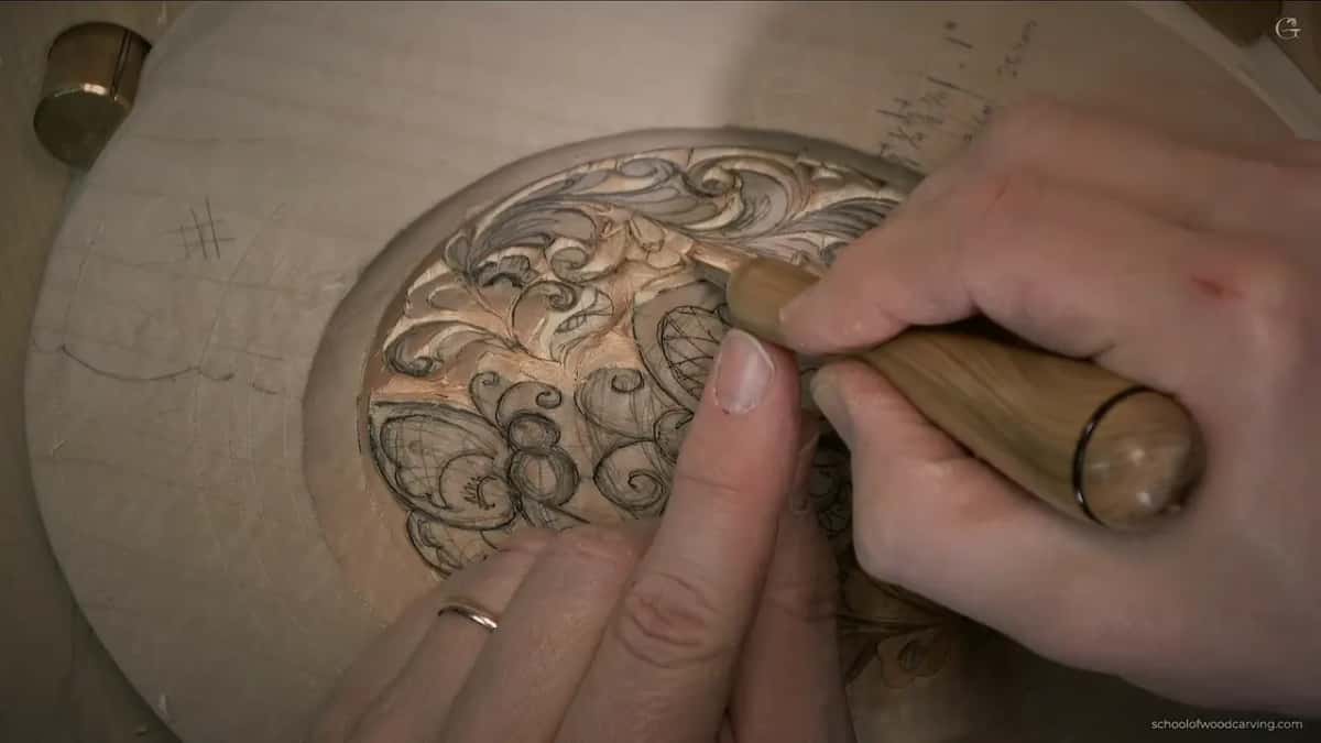 Left index finger pressed near the blade while the right hand steers a long handle