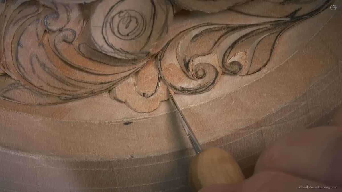 A needle-thin blade points into a little flower under a scroll