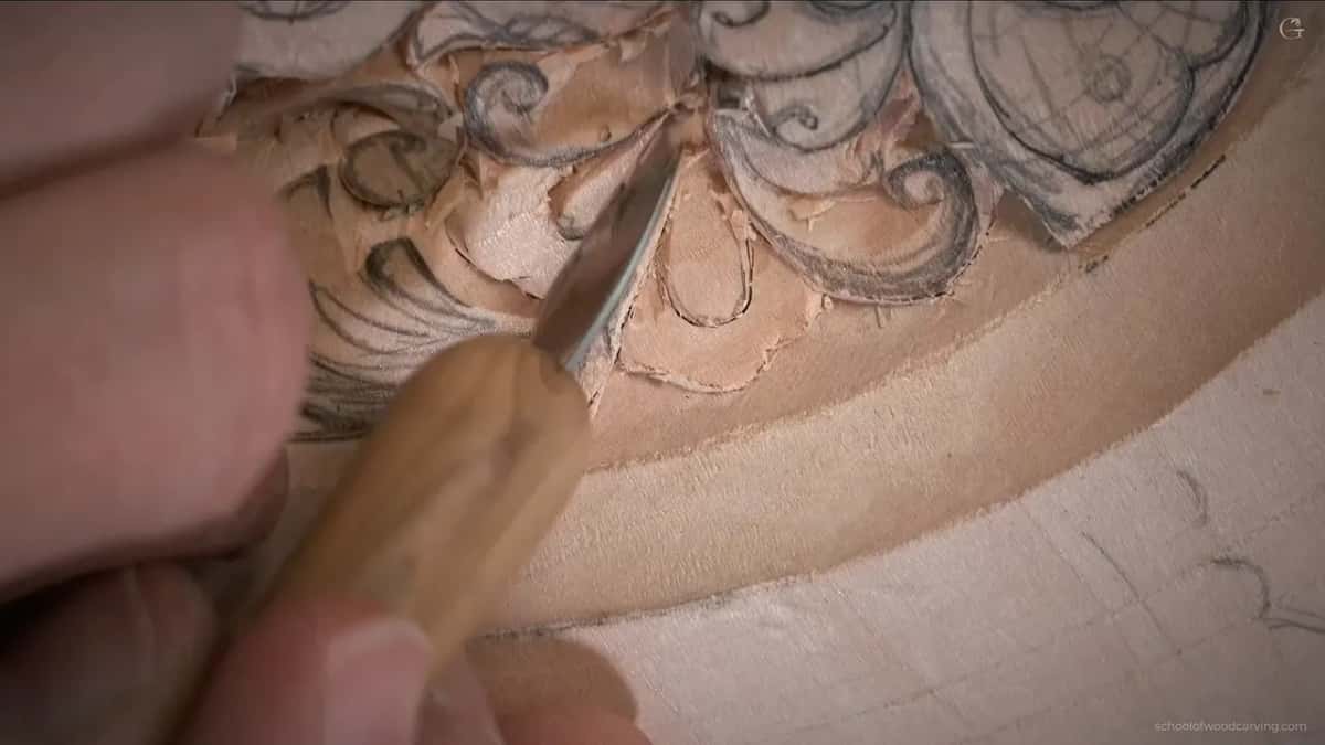 Fingers pinch the handle close to its blade while the point digs into a corner