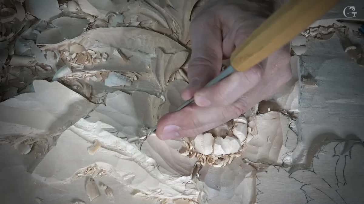 Yellow handled gouge in the fingers near a ring of petals
