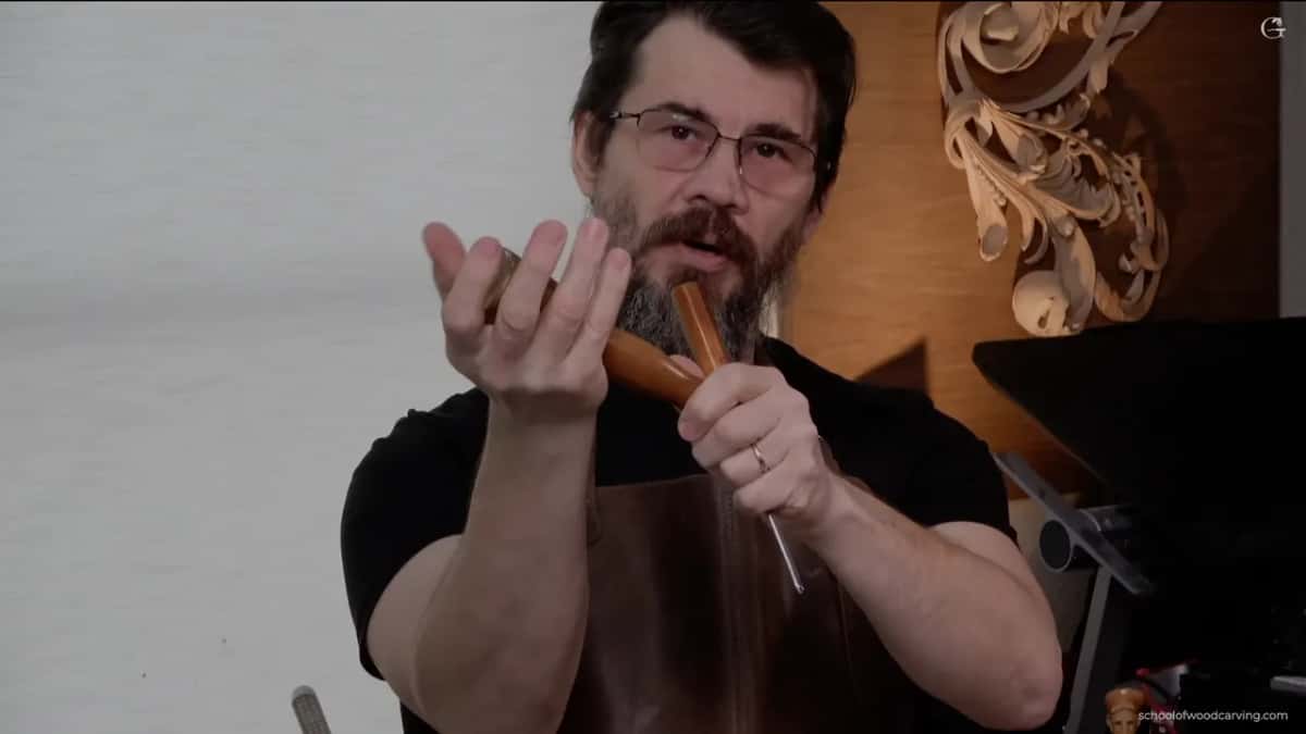 A mallet lying in an open palm rather than gripped by the handle, which is how he keeps a tap light.