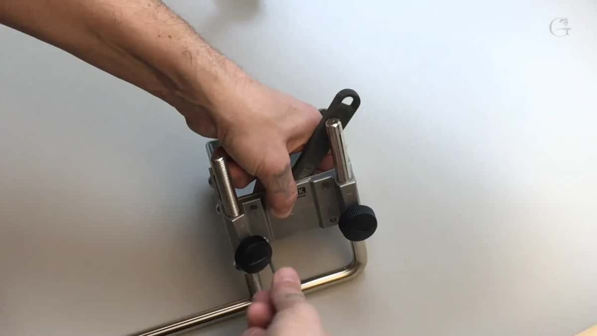 Two hands on the bar assembly, knobs and threaded posts and all.