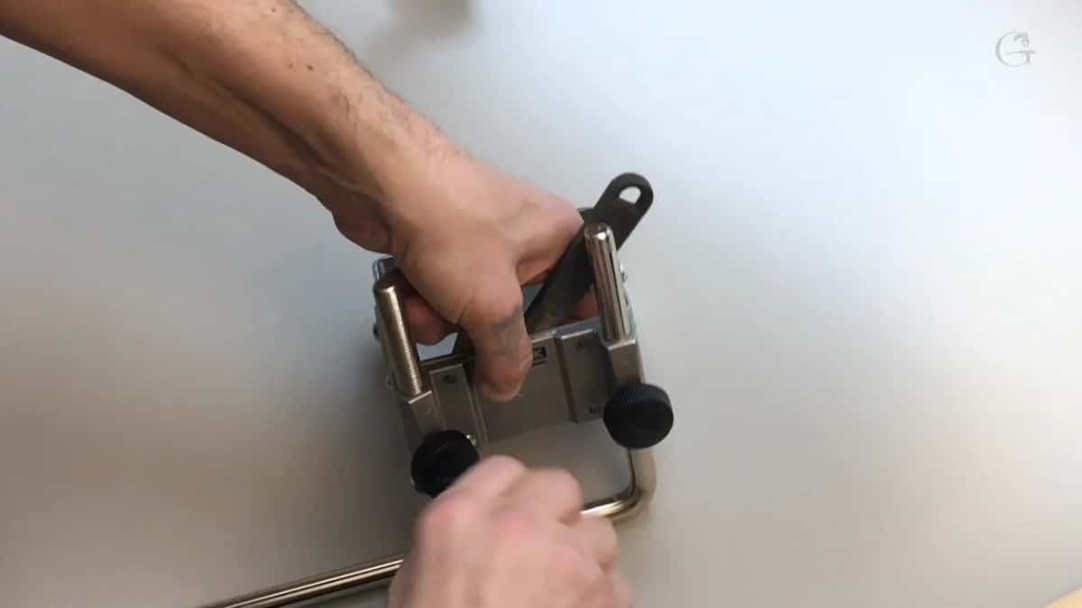 Tightening the bar down into its bracket, with the frame of the mount kit around it.
