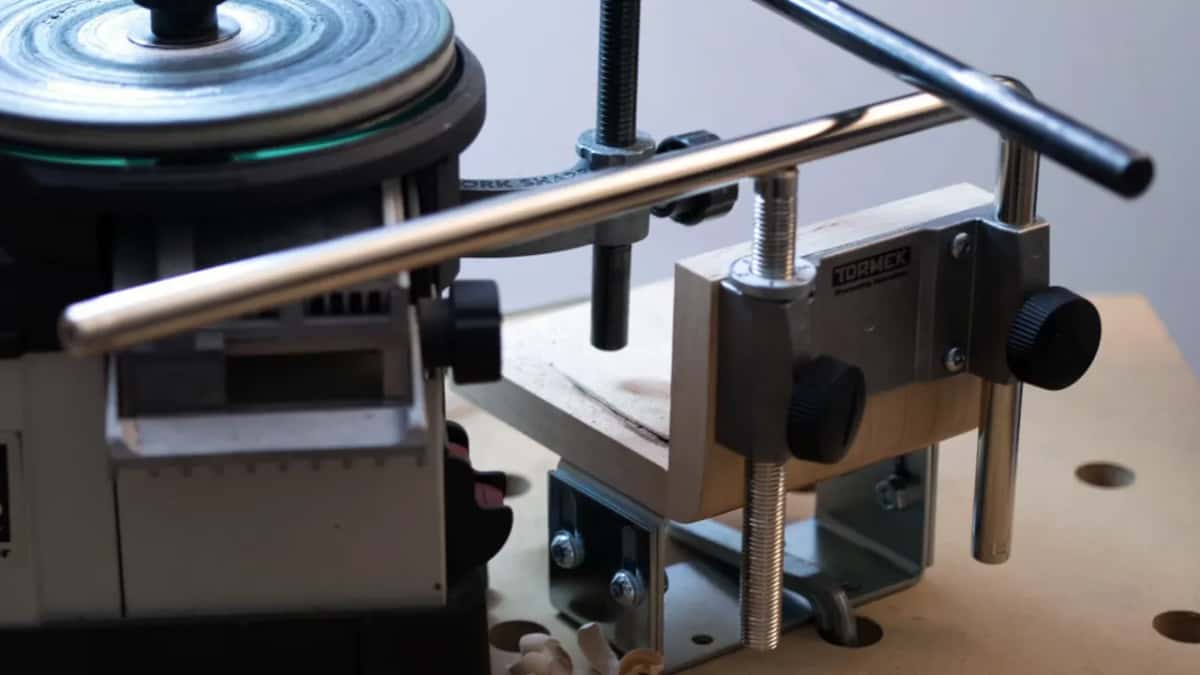 Close on the bracket, with TORMEK stamped across the face of it and a steel angle underneath.