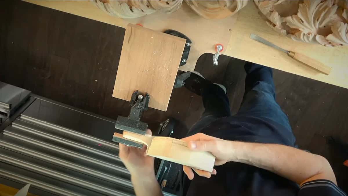Holding a blank steady with a chisel lying ready above it on the bench top