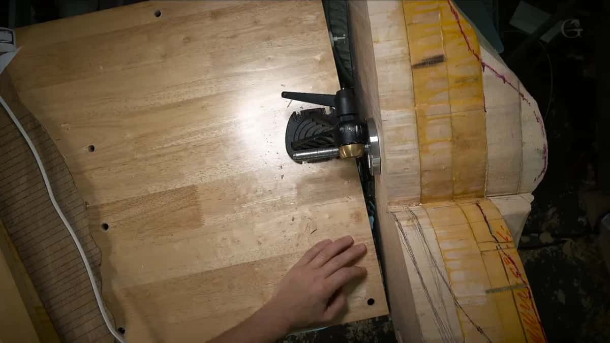 Plywood jig plate drilled through in a row of holes, the vise head bolted into one of them