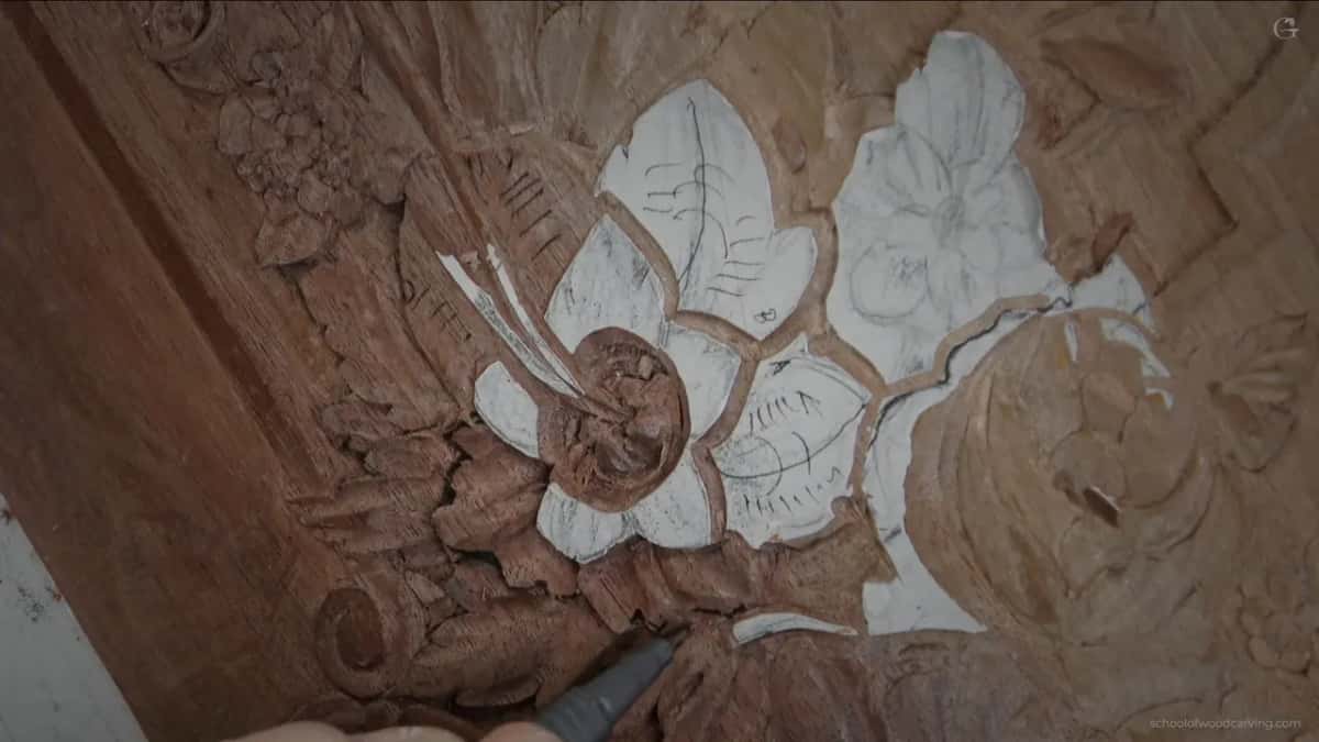 The carved flower and its leaf, divisions rounded rather than cut to a point, with no hand in the frame at all.