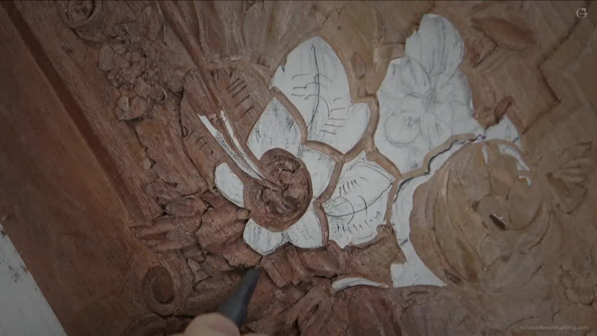 The flower with a dark tool tip entering at the bottom, where a back bevel lets the blade ride over the raised middle.