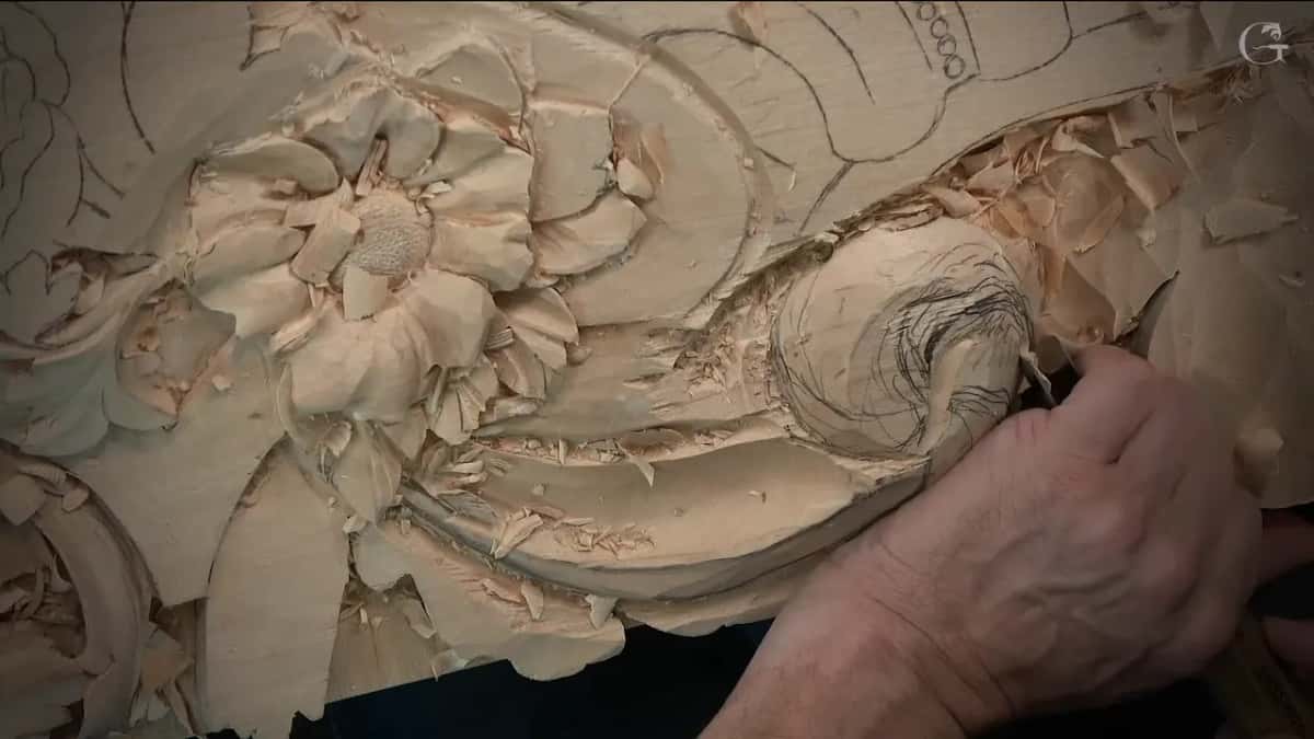 Hand steering a small gouge along the pencil swirl drawn on the dome, chips piled up all around it