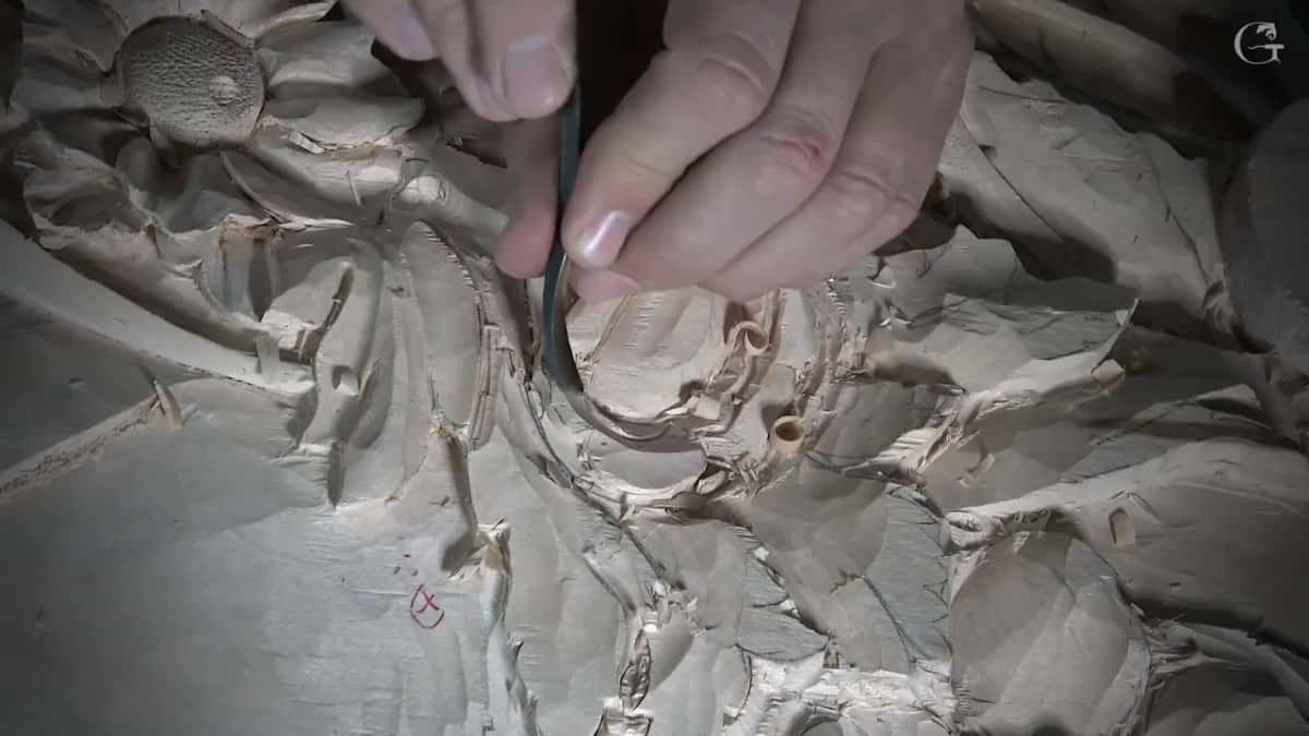 Spoon gouge tucked under the edge of a petal, with a punched flower center just above it