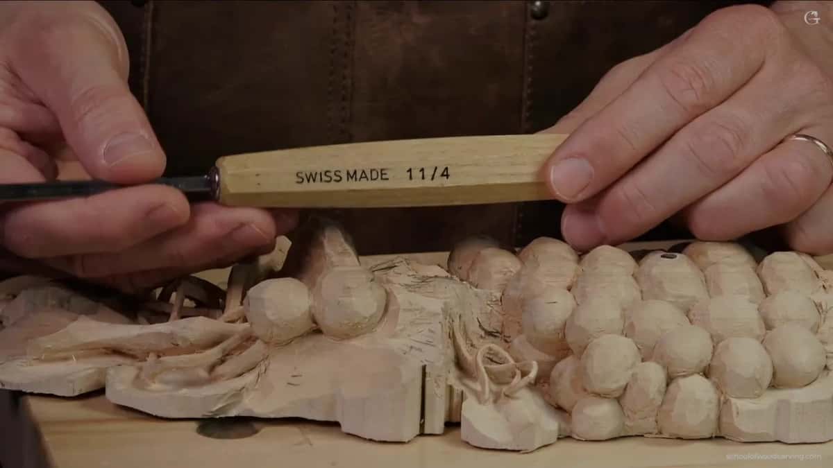 Tool stamped SWISS MADE 11/4, a number 11 veiner four millimetres across, held over the carving