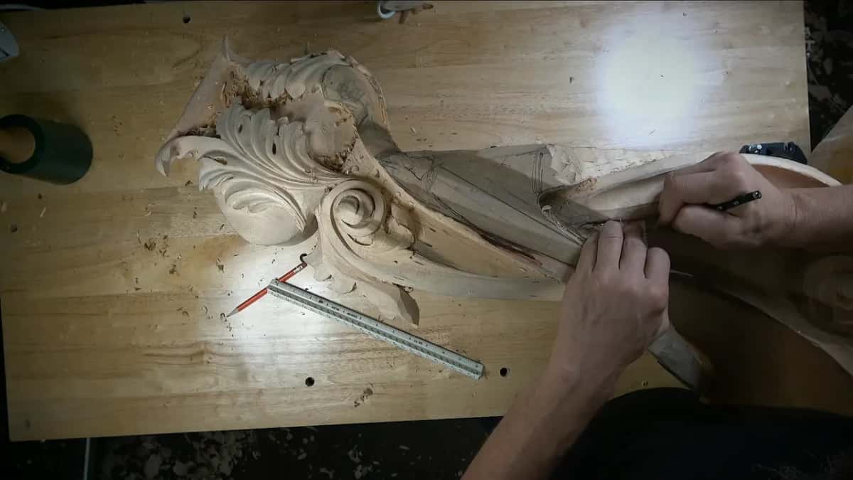 Pencil in hand, marking the band beside the carving