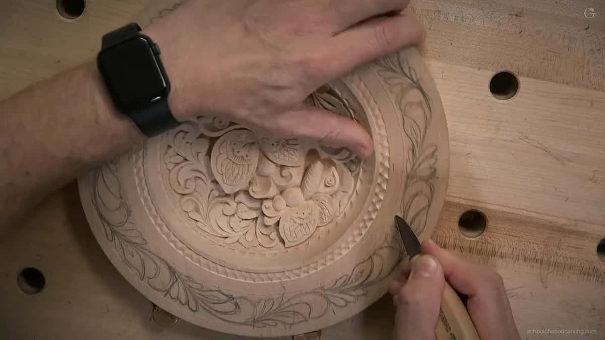 A short knife starts around the drawn scrolls near the bottom of the plate