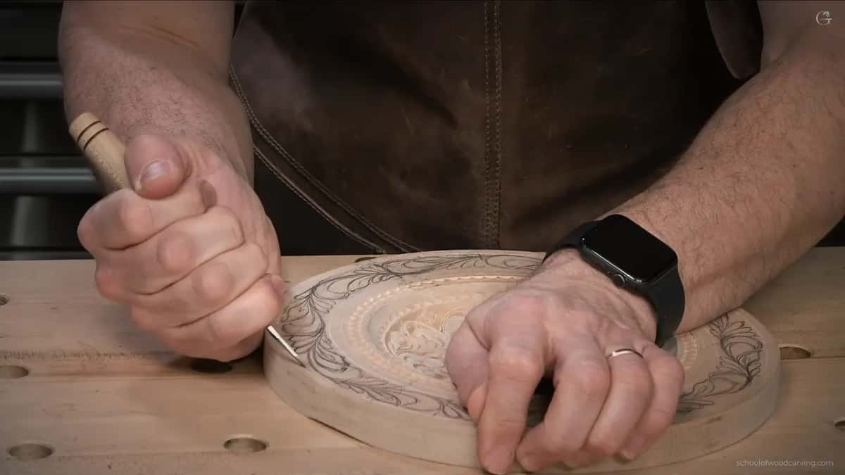 From the side, a fist presses the knife point in